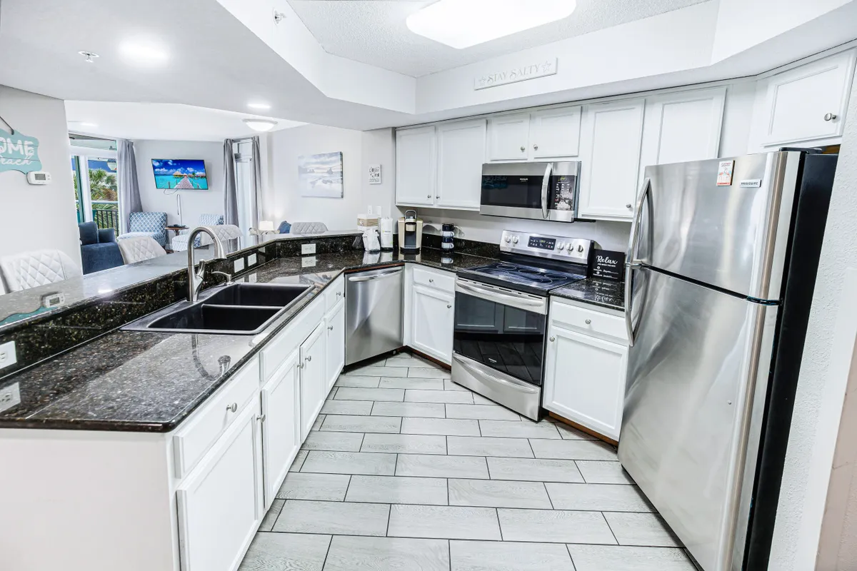 This image features sleek granite countertops, stainless steel appliances, and a well-organized sink area. The space radiates an inviting atmosphere, ideal for both cooking and entertaining.